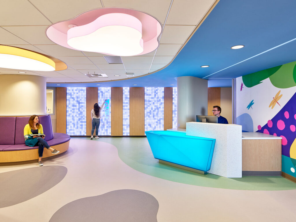 Reception area at UPMC Children's Harrisburg featuring colorful architectural lighting, playful ceiling forms, and a welcoming pediatric healthcare environment.
