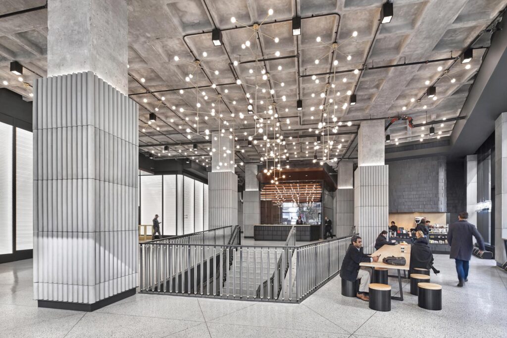 Beyond Lux Nomad Tower lobby lighting design in New York, featuring a ceiling grid of point lights and ribbed concrete columns